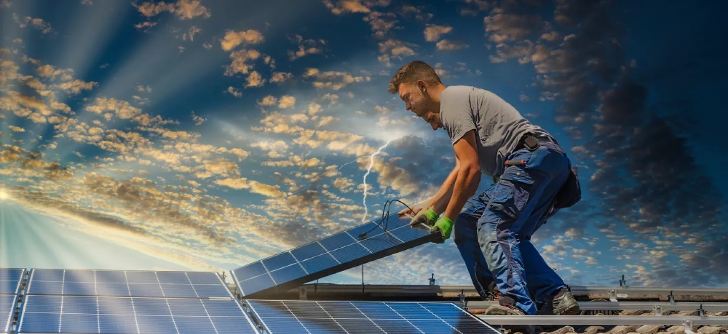 Handwerker auf dem Dach installiert Photovoltaik-Module