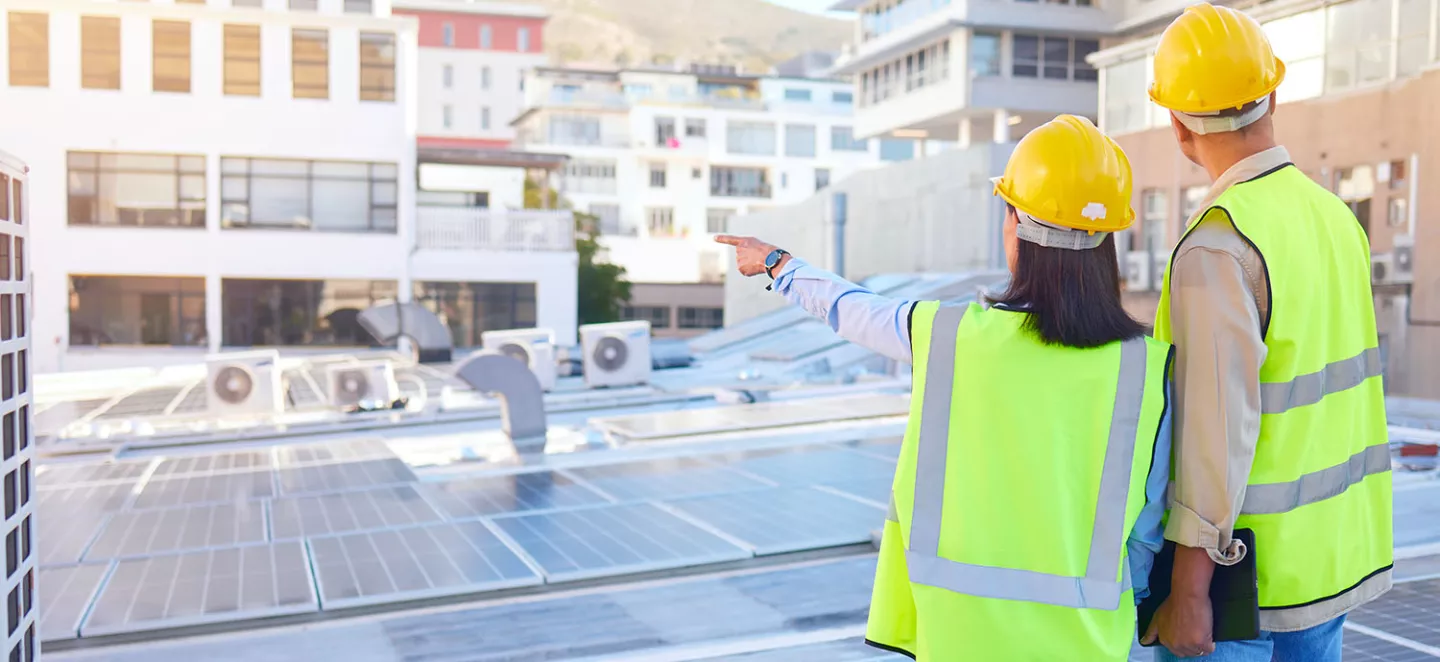architetto ed ingegnere che osservano un impianto fotovoltaico sul tetto di un'azienda