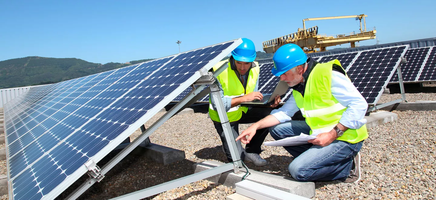 ingegneri ispezionano pannelli fotovoltaici sul tetto di una fabbrica