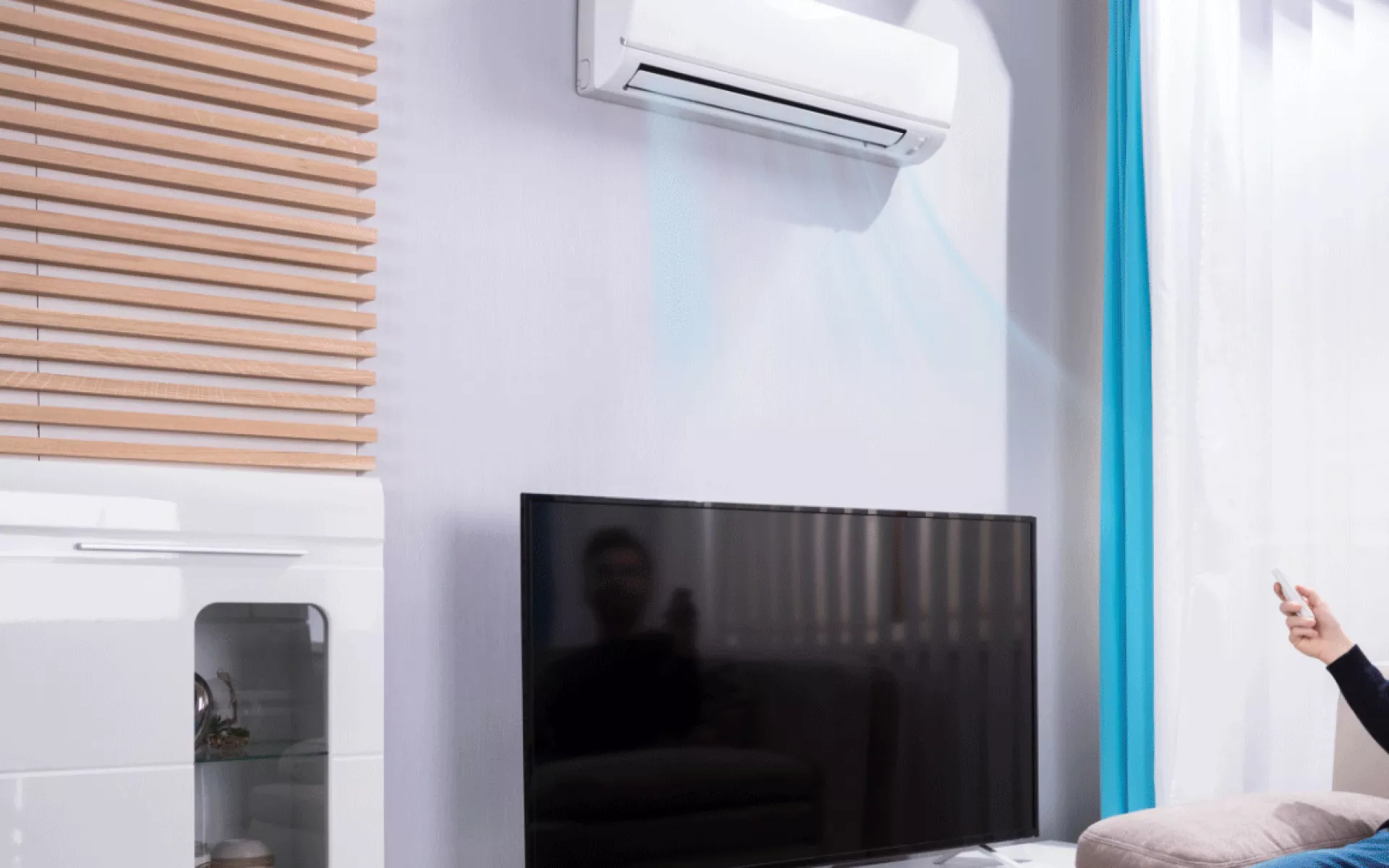 Man sitting on couch looking at airconditioning