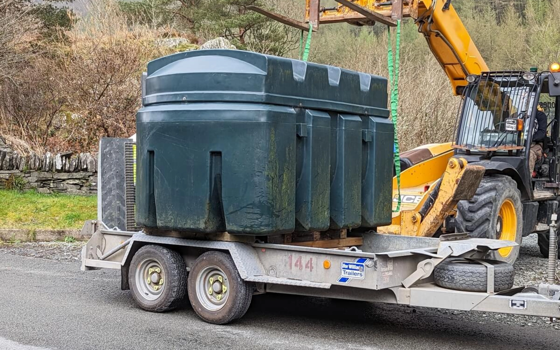 Ein alter Heizöl-Tank wird von einem Kran abtransportiert.