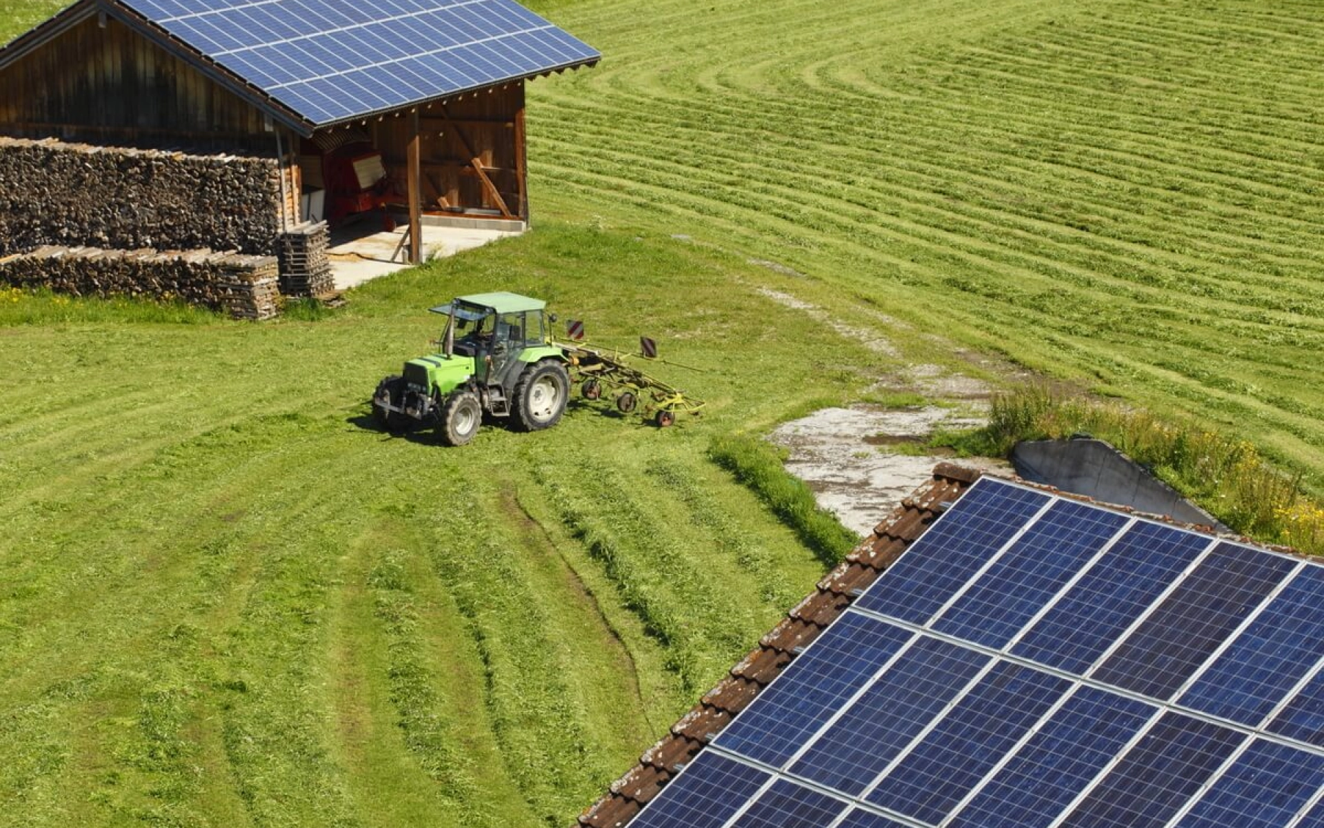 Eine Solaranlage auf einer Scheune mit Traktor davor.
