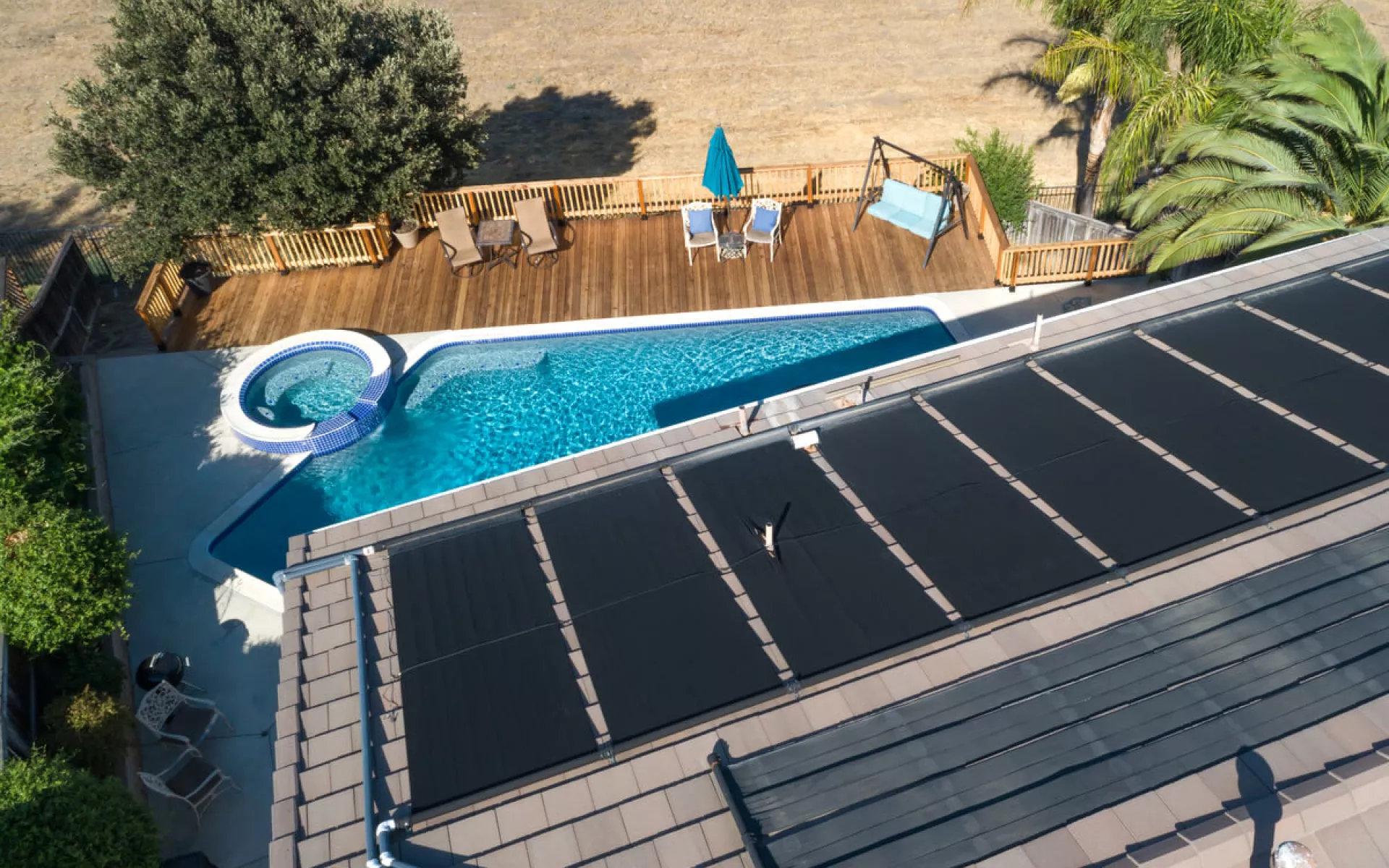 Flachkollektoren für Solarthermie auf einem Dach mit Pool.  