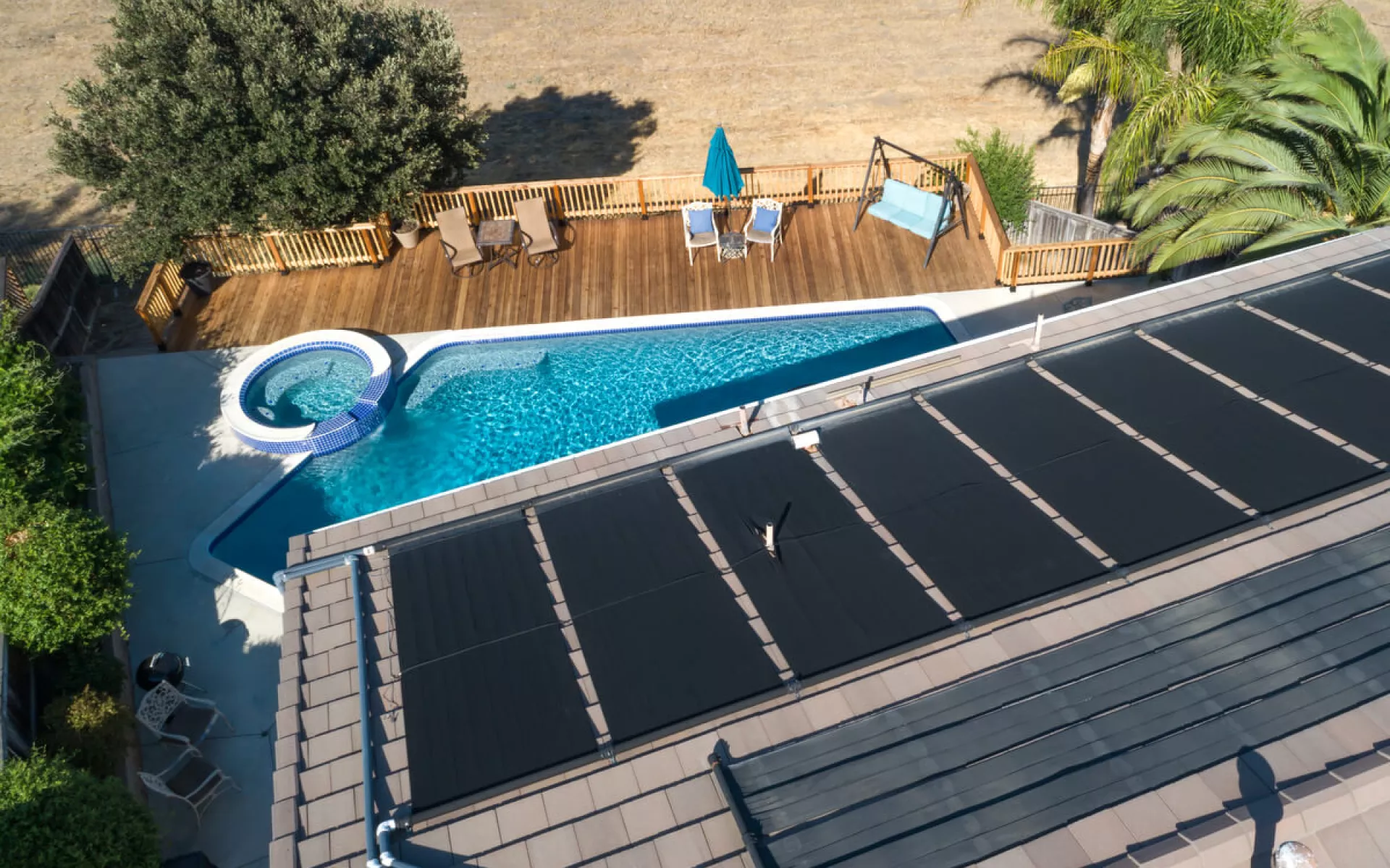 Flachkollektoren für Solarthermie auf einem Dach mit Pool.