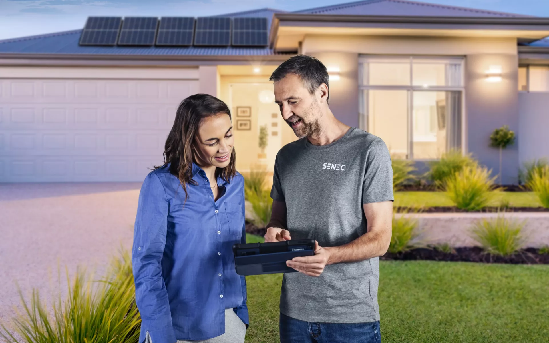 installer with customer in front of a house