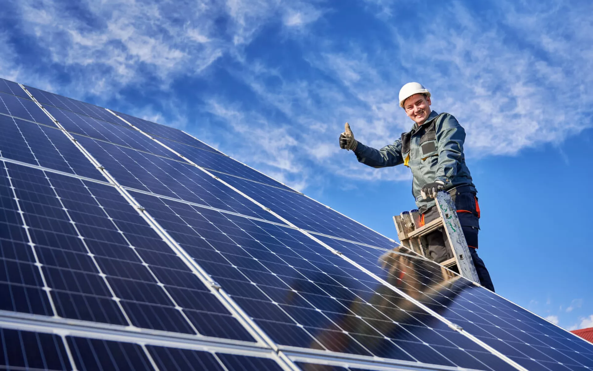 Ein Installateur begutachtet neu installierte Solarmodule und vergewissert sich von der Leistungsfähigkeit der Module.
