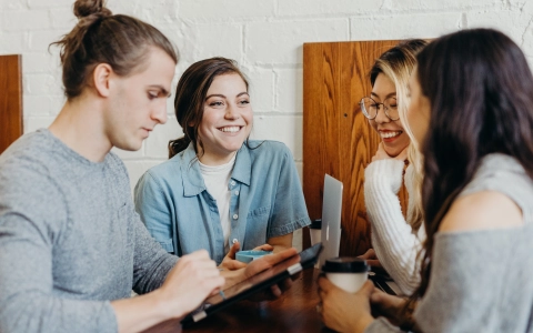 Persone sedute ad un tavolo che collaborano