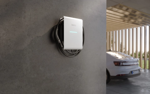 SENEC.Wallbox pro s on house wall next to e-car
