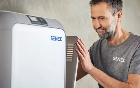 Installer with an opened SENEC.Home battery storage device