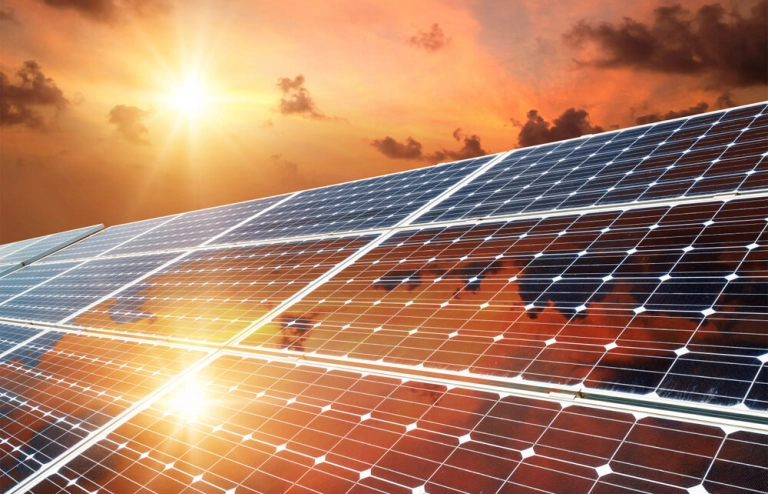 Solar-Panels mit großer Sonne und schönem rotem Himmel.