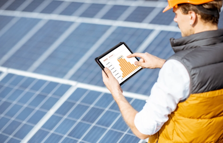 Solar-Installateur berechnet mit Tablet die Solaranlage eines Hauses vor Ort.