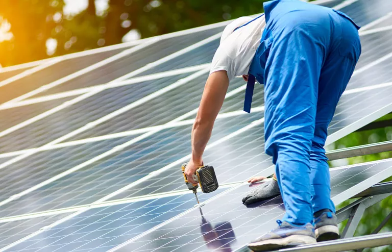 Un installatore intento al fissaggio di un pannello di un impianto Fotovoltaico industriale