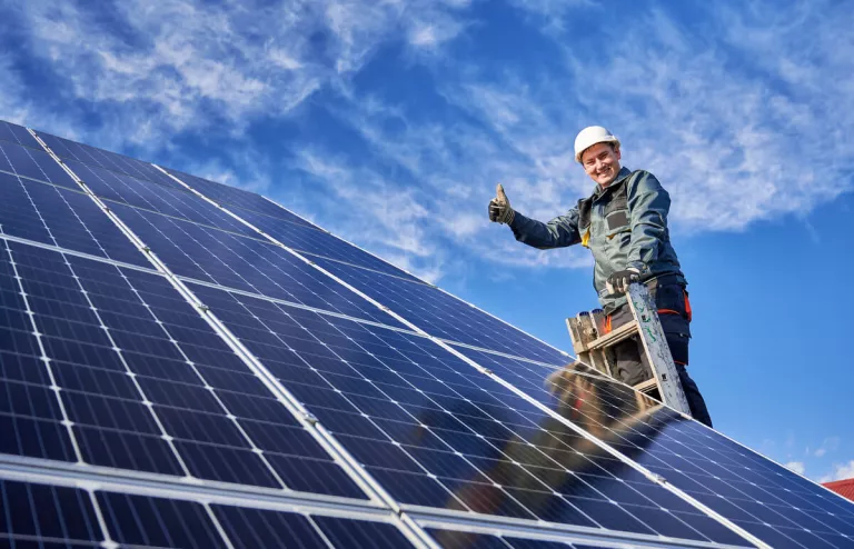 Ein Installateur begutachtet neu installierte Solarmodule und vergewissert sich von der Leistungsfähigkeit der Module.