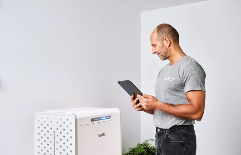 Ein Service-Mitarbeiter verbindet einen Senec-Speicher per Tablet und App mit dem Internet.