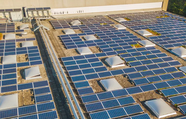 impianto fotovoltaico sul tetto di un capannone di una fabbrica in una giornata soleggiata
