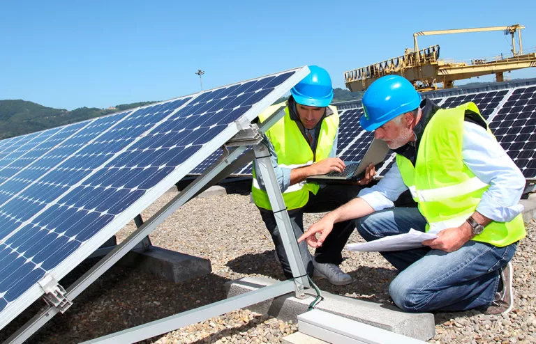 ingegneri ispezionano pannelli fotovoltaici sul tetto di una fabbrica