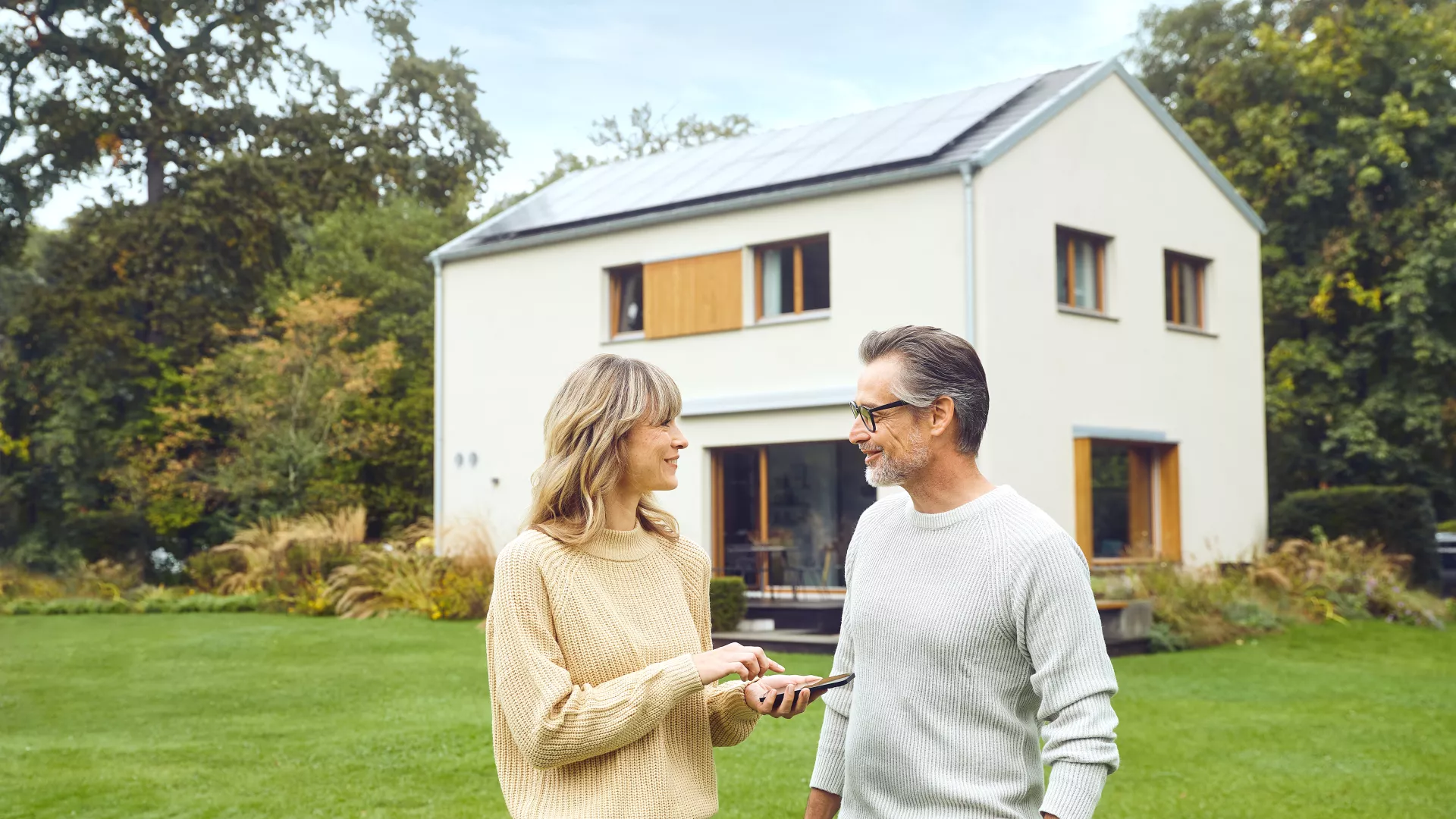 Familie vor Haus mit Photovoltaikanlage