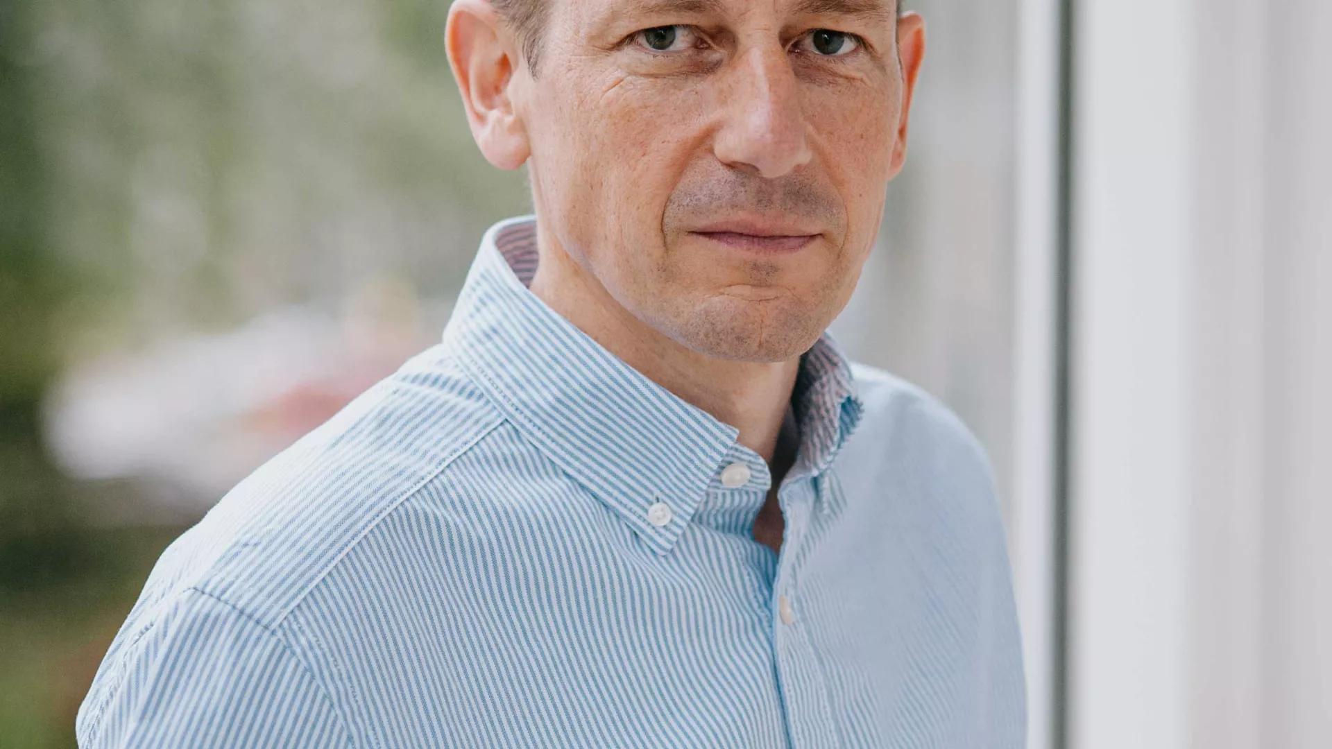 Johann Georg von Hülsen (CEO der SENEC GmbH) in blauem Hemd vor Fenster
