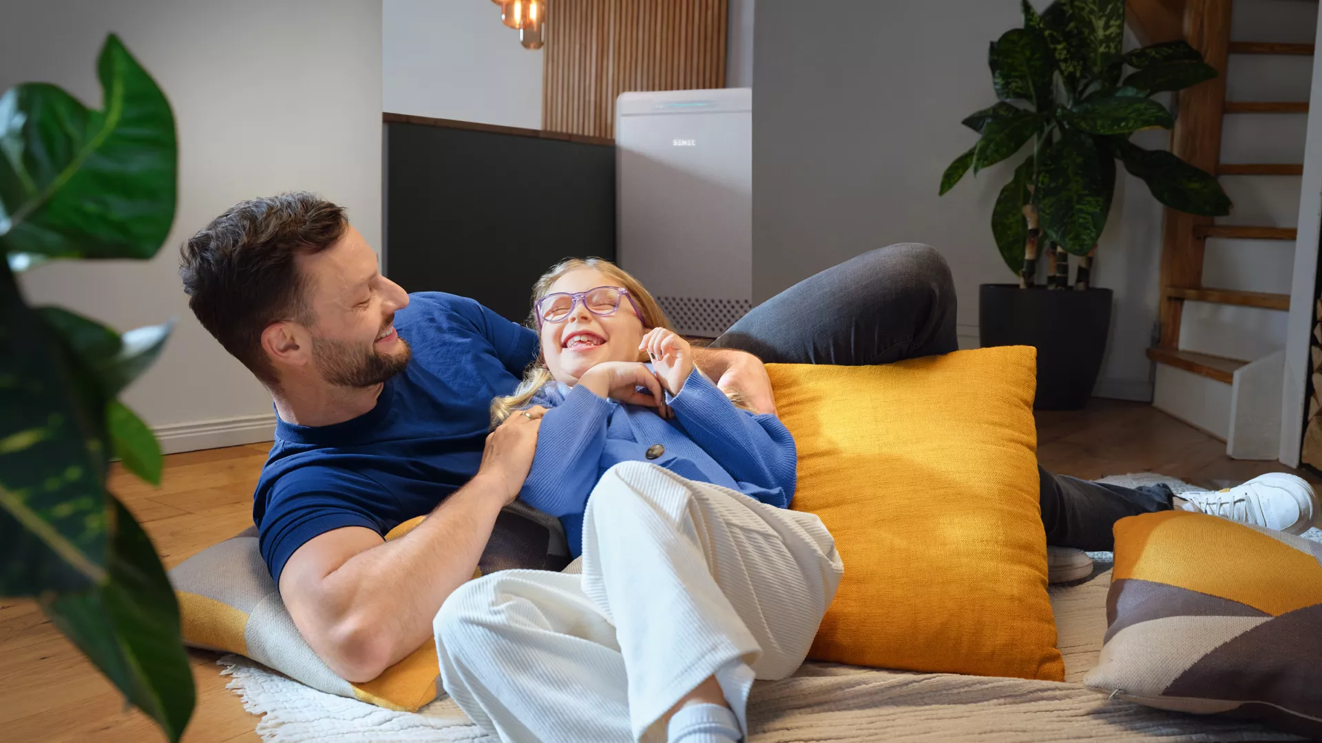 Vater spielt mit Tochter, im Hintergrund steht der SENEC.Home P4