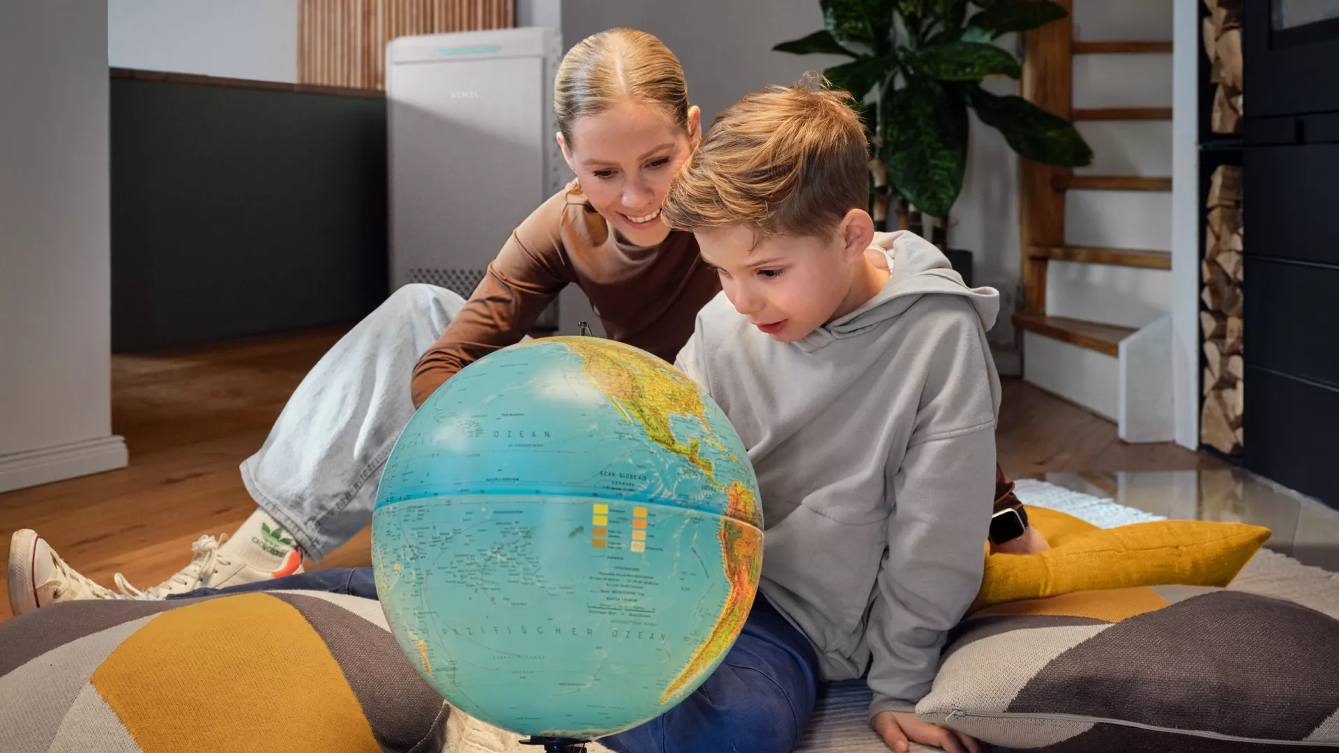 Mutter schaut sich mit Sohn leuchtenden Globus vor SENEC.Home P4 an