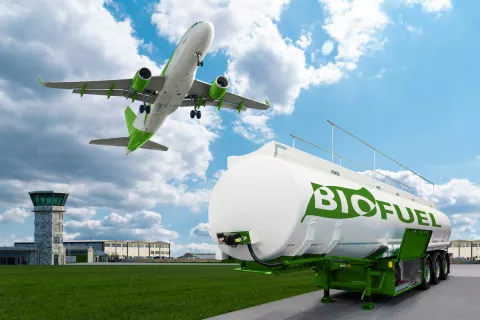 Ein Flugzeug startet und im Vordergrund steht ein Tankwagen mit der Aufschrift Bio-Fuel.