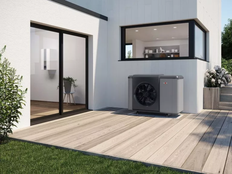 Eine Wärmepumpenheizung gut integriert vor einem modernen Einfamilienhaus.