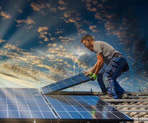 Handwerker auf dem Dach installiert Photovoltaik-Module