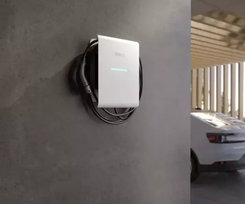 Eine moderne Wallbox hängt an der Wand von einem Carport.