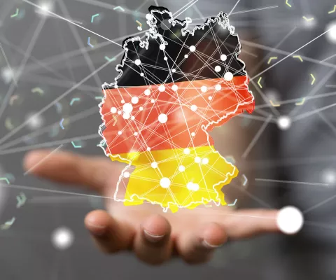 Grafik einer Deutschlandkarte, die von geografischen Linien durchzogen ist und auf einer Hand schwebt.